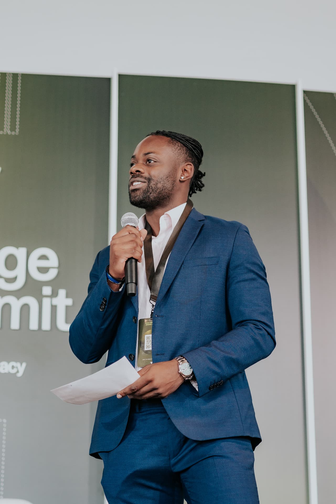 Ayo Oyelola speaking on stage at a public event